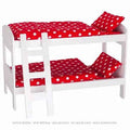 White dollhouse bed with red polka dot bedding and pillow on a white background