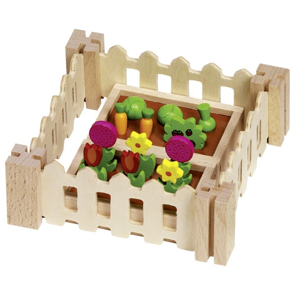 Wooden toy garden with animals and vegetables on a white background