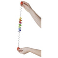 Colorful cat toy with a string held by two hands on a white background