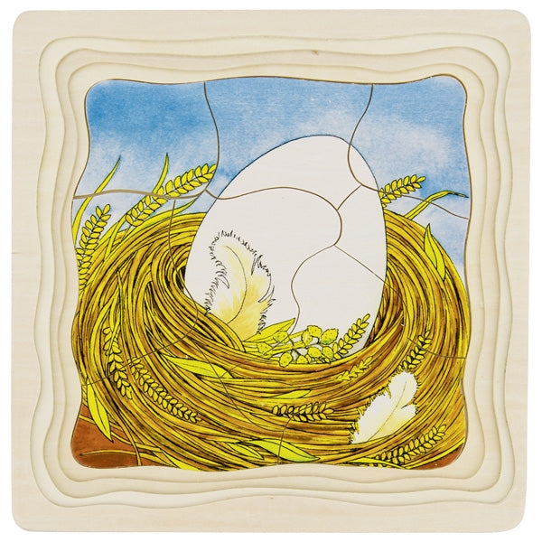 Decorative tile with a stylized depiction of a bird's nest, egg, and wheat on a textured beige border.