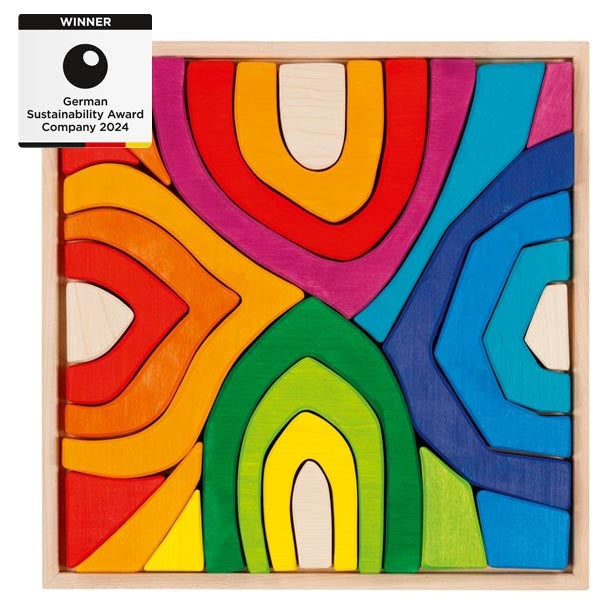 Colorful wooden puzzle with abstract design and German Sustainability Award 2024 badge.