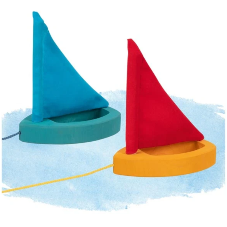 Two colorful toy sailboats with blue and red sails on a white background