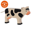 Toy cow figure with black and white spots on a white background