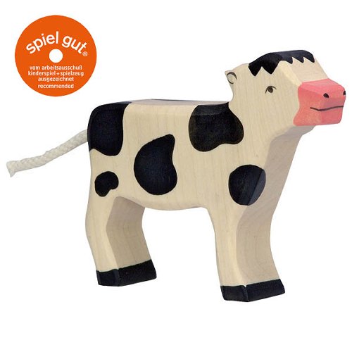Wooden cow toy with black spots on a white background