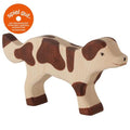 Wooden toy cow with brown patches on a white background