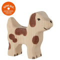 Wooden dog figurine with brown spots on a white background