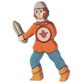 Wooden toy figure of a knight holding a sword and shield on a white background