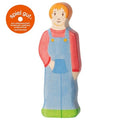 Wooden toy figure of a girl wearing a red shirt and blue overalls on a white background